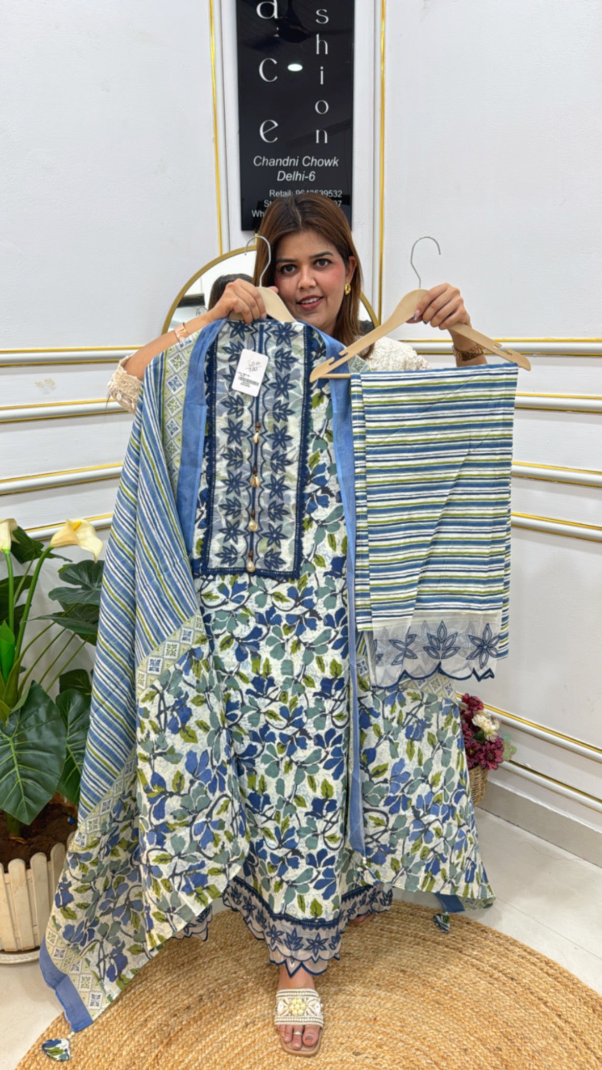 Woman showcasing an elegant cotton suit set with floral patterns and a stylish dupatta